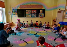 Dzieci siedzą na podłodze, Wiola zaczyna zajęcia