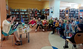 Dzieci siedzą już na krzesełkach, a Pani Alicja czyta kolejną książeczkę