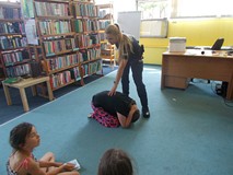 dziewczynka pokazuje pozycje ovchrony przed groźnym zwierzęciem pod nadzorem policjantki