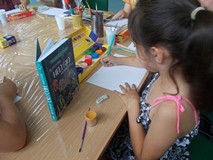 dziewczynka maluje prace plastyczną inspirując się książką Hela foka