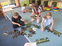 dzieci układają ogromne puzzle z wizerunkiem zwierząt