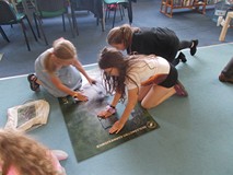 dzieci układają ogromne puzzle z wizerunkiem zwierząt