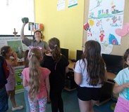 leśniczka pokazuje dzieciom kasztany