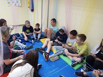 Dzieci siedzą na materacach podczas zabawy