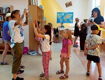 Pani Magda pomaga dzieciom w obsłudze aparatu