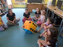 dzieci grają dużą kostką do gry