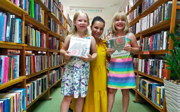 dziewczynki i bibliotekarka pozują do zdjęcia