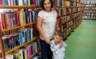 bibliotekarka i chłopiec prezentują książkę