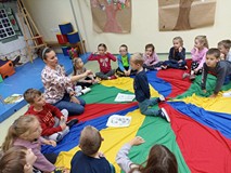 DZieci i bibliotekarka siedzą na chuście
