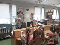 Bibliotekarka prezentuje karte bibloteczną