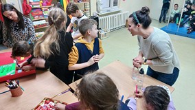 bibliotekarka pomaga dzieciom w tworzeniu makiety