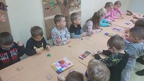 Dzieci przy stolikach wykonują prace plastyczne