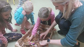 Bibliotekarka układa z dziećmi jesienną makietę