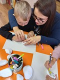 Jesienne warsztaty kamyczkowe- chłopiec z mamą maluje swoją ulubioną postać z bajki
