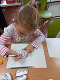Jesienne warsztaty kamyczkowe- dziewczynka maluje swoją ulubioną postać z bajki