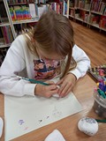 Jesienne warsztaty kamyczkowe- dziewczynka maluje swoją ulubioną postać z bajki