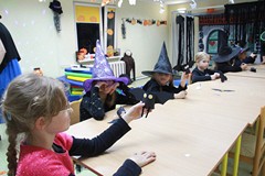 dziewczynka pozuje z papierowym nietoperzem