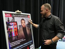 Wojciech Chmielarz podczas podpisywania plakatu.