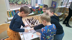 Dzieci w czytelni grają w szachy