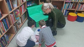 Bibliotekarka pokazuje chłopcom książkę