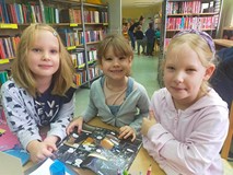 Dziewczynki przeglądają książki w czytelni
