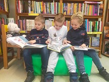 Chłopcy siedzą na materacyku i czytają książki