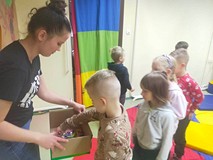 Dzieci otrzymują nagrody, które były ukryte w tajemniczym kartonie