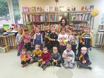 Dzieci z bibliotekarką prezentują różdźki