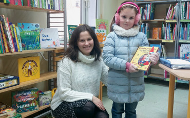 Dziewczynka z bibliotekarką prezentują książkę z akcji Mała książka - Wielki Człowiek