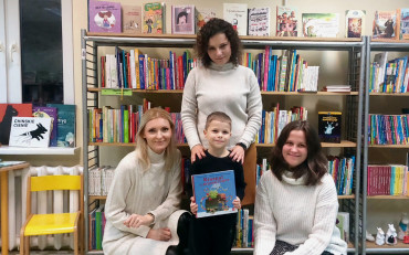 Jurek w towarzystwie trzech bibliotekarek pozuje do zdjęcia z książeczką