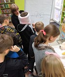 Trzecioklasiści próbują rysować misia  mając zasłonięte oczy