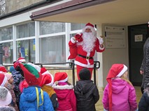Dzieci z przedszkola nr 8 z Mikołajem przed budynkiem biblioteki