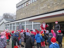 Dzieci z przedszkola nr 8 z Mikołajem przed budynkiem biblioteki