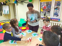 Dzieci wykonują prace plastyczne przy stolikach