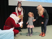 Mikołaj przekazuje nagrodę dziewczynce.