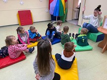 Dzieci siedzą na materacach i rozmawiają o tradycjcach bożonarodzeniowcy