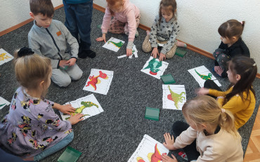 Grupa Wisienki układa puzzle z wizerunkiem dinozaurów