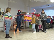 Bibliotekarze i dzieci podczas zabawy piniatą.