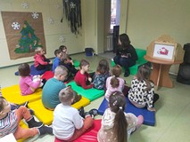 Dzieci siedzą na materacach i rozmawiają o tradycjcach bożonarodzeniowcy