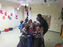 Dzieci wraz z bibliotekarką owineli sie łańcuchem choinkowym