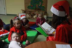 Dzieci siedzą na materacach i słuchają opowiadania