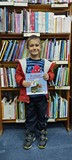 chłopiec pozuje do zdjęcia z pakietem Mała książka, Wielki człowiek