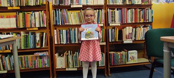 dziewczynka pozuje do zdjęcia z pakietem Mała książka, Wielki człowiek