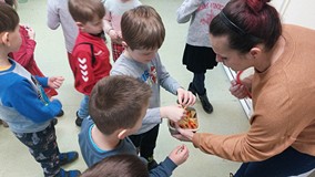 Bibliotekarka częstuje dzieci żelkami