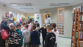 Bibliotekarka oprowadza dzieci po bibliotece