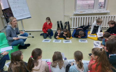 Uczniowie słuchają opowieści bibliotekarki