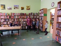 dzieci stoją przy ragałach z książkami
