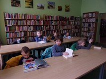 na zdjęciu dzieci oglądają książki