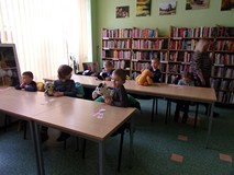 dzieci siedzą przy stołach