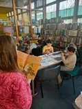 Bibliotekarka czyta bajkę uczestnikom zajęć.